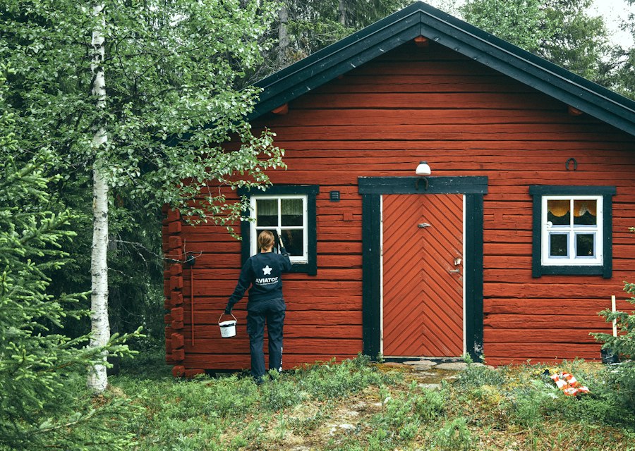 Painter applying a fresh coat of paint to the exterior of a residential home